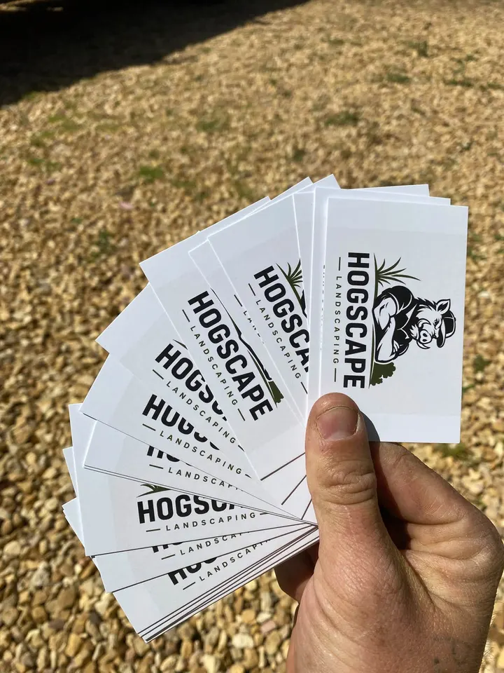 A fan of HogScape business cards held in a hand