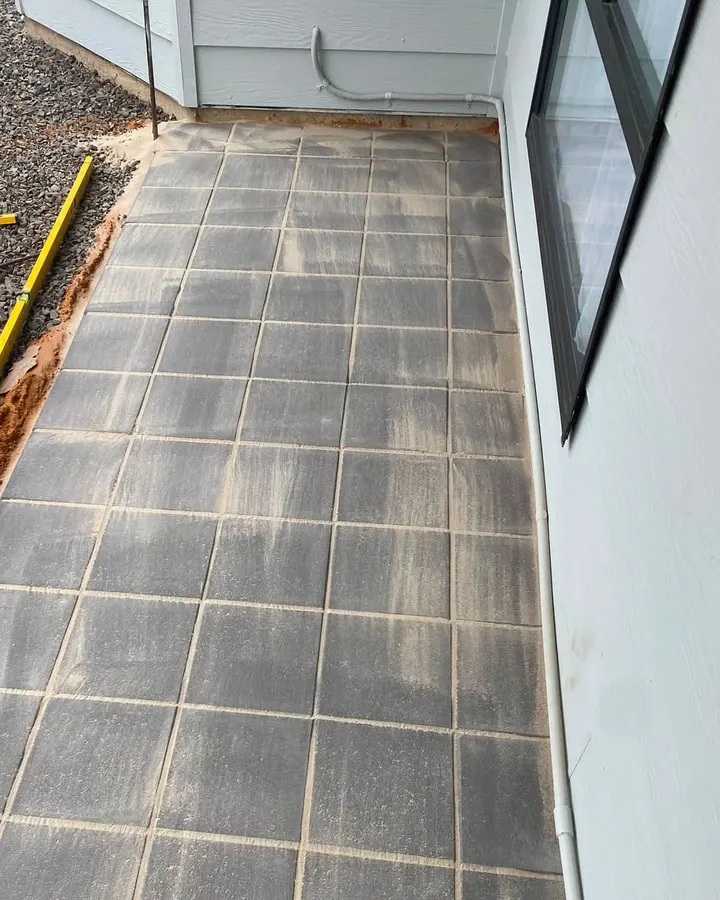 Pavers laid down a side path, a spirit level on the gravel beside them