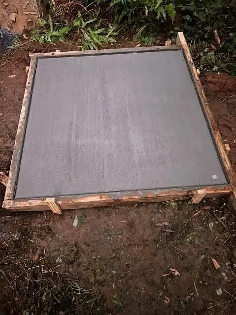 A concrete slab with a smooth surface inside timber formwork on red dirt